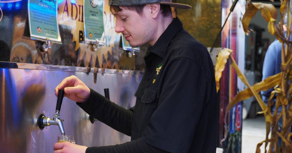 employee pouring beer via tap