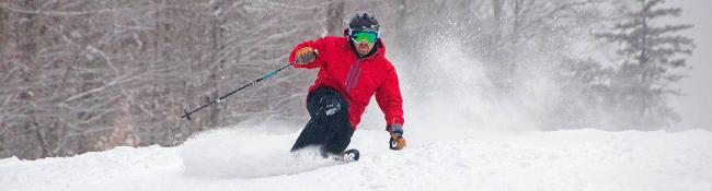 man in a red coat skiing at gore mountain