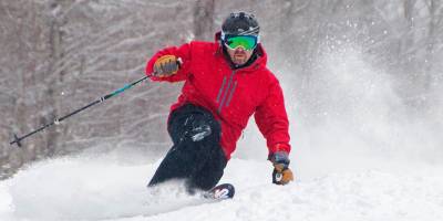 man in a red coat skiing at gore mountain