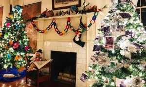 decorated Christmas trees by a fireplace
