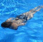 woman swims underwater in pool