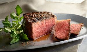 steak on a plate, a couple pieces cut off