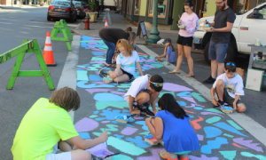 group of kids painting a sidewalk