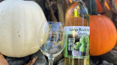 ledge rock hill winery bottle and glass in between a white pumpkin and orange pumpkin