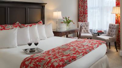 guest bedroom at saratoga arms with two glasses of wine on the bed