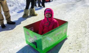 little girl in a homemade minecraft box sled
