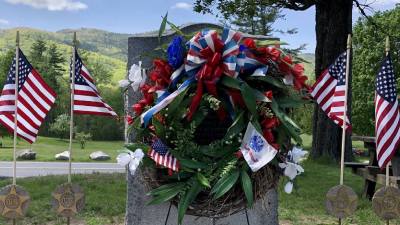 gravesite memorial with american flags and wreath