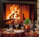 restaurant table set up by fire in fireplace