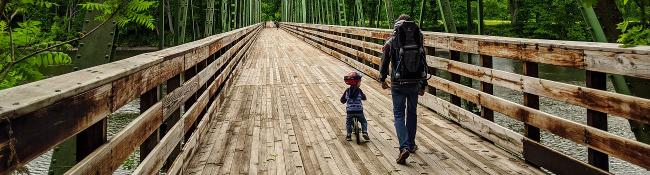 kid and dad walk/hike over a bridge