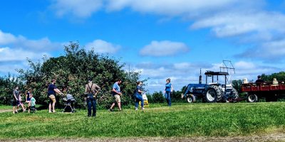 people walking towards a hay ride and tractor