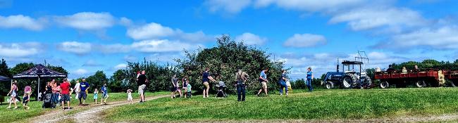 people walking towards a hay ride and tractor