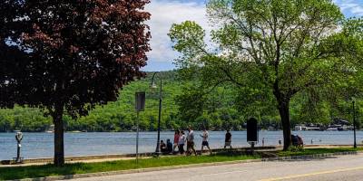 people walking by lake george in springtime