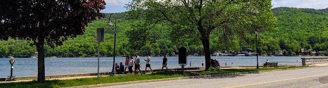 people walking by lake george in springtime