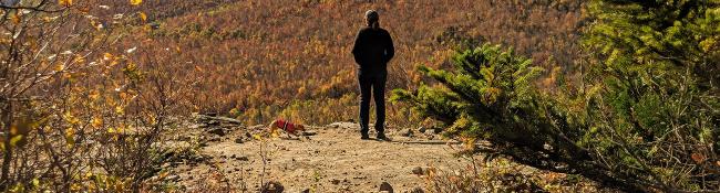 hiker and dog on mountain summit in fall