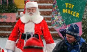 santa near sign that says toy maker