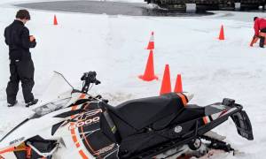 guy by snowmobile by water