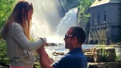 woman being proposed to with waterfall in the background