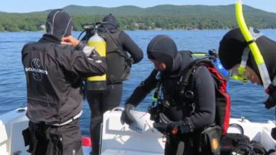 scuba divers on boat on lake george