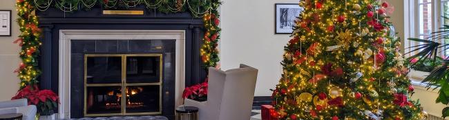 queensbury hotel lobby fireplace and tree decorated for christmas