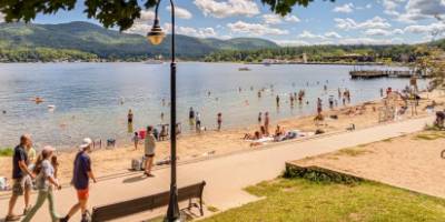 people walking by lake george beach