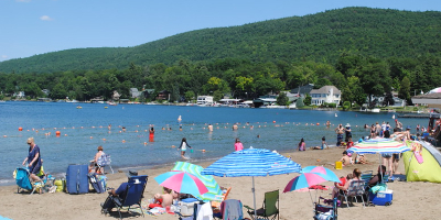 people walking by lake george beach
