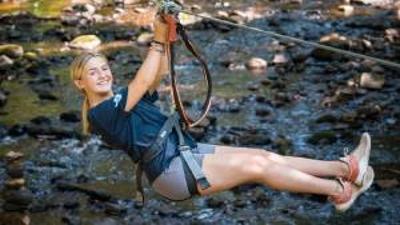 woman ziplining over water