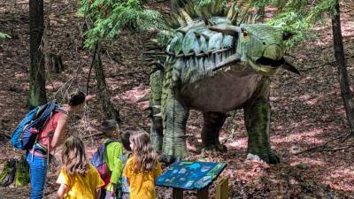mom with kids look at dinosaur