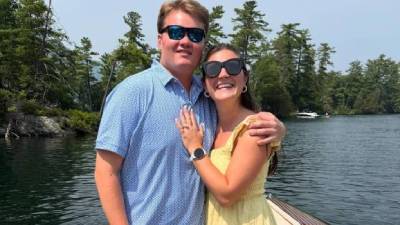 couple poses on boat on lake george