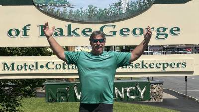 ray posing in front of heritage of lake george sign